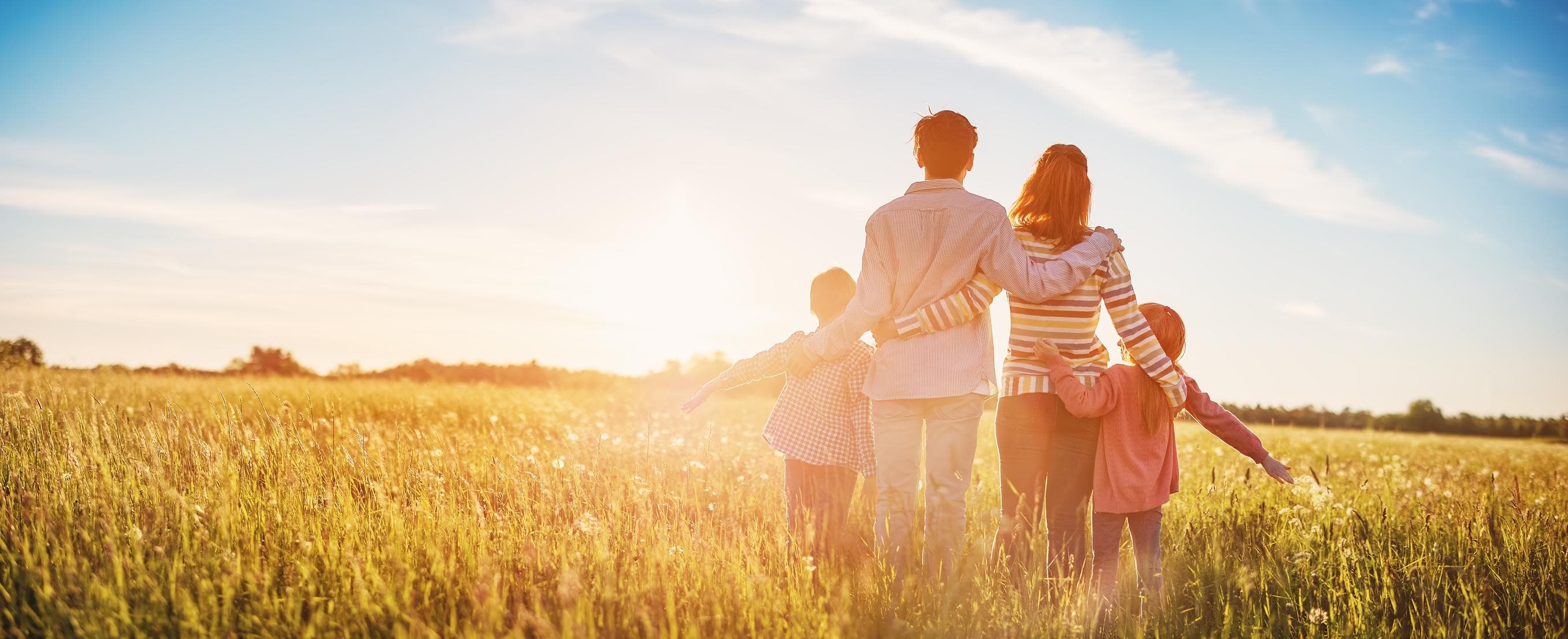 Familia abrazada en un campo del sur de Chile al atardecer